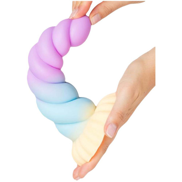 A hand bending the soft Mistique dildo.