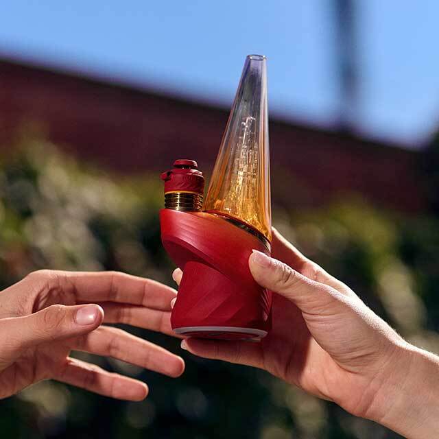 Puffco Peak Pro 3DXL Daybreak Edition being handed between two people.