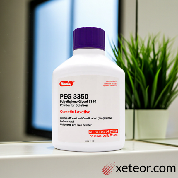 Bottle of Rugby PEG 3350 osmotic laxative on a bathroom counter next to a large green fern and a sink faucet.