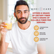 Man holding a glass of orange fiber supplement drink featuring 6g dietary fiber and 5g soluble fiber callouts
