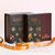 Makana Confections Bourbon Truffles 130 grams and Dark Chocolate Macadamia Toffee Crunch 395 grams boxes displayed side by side with a branded copper ribbon laid out tastefully in front.