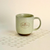 Makana branded ceramic mug with speckled glaze and brown base