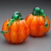 "Red Splash" hand blown glass pumpkin; vivid orange color with splashes of red and mottled pattern from imbedded clear chips of glass to create surface design. Shown here with Green optic stem. Beautiful on their own or in groups, for your Seasonal displays or splash of color all year long!