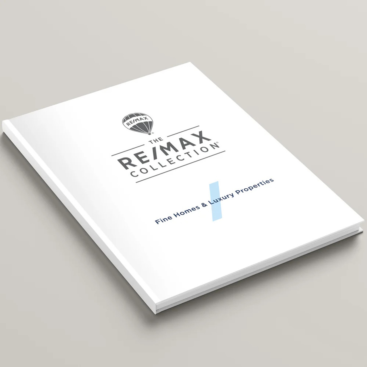 The RE/MAX Collection hardcover presentation cover – front angled view, white soft-touch finish with modern RE/MAX logo