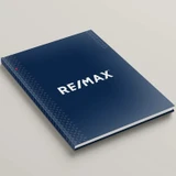 Angled view of RE/MAX Dusk Blue hardcover presentation cover with soft-touch matte finish and full-color branding