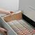 Smead 10734 reinforced tab kraft file folder being placed into a drawer filing cabinet with labeled alphabetical file folders