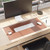 Smead vegan leather desk pad in Saddle brown on office desk with keyboard, mouse, monitor and writing accessories