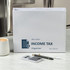 Smead All-in-One Income Tax Organizer on kitchen counter with calculator and pens