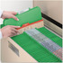 Hand placing Smead green classification into drawer, with tab at top.