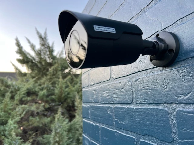 Black SureVision bullet camera mounted neatly on an exterior brick wall
