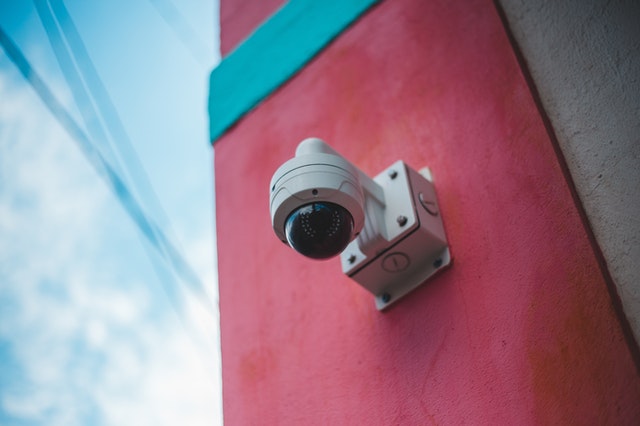 Dome CCTV camera on red wall