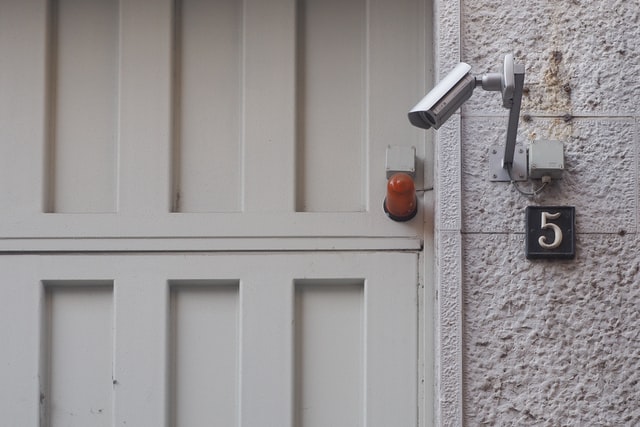 security camera near white wooden door
