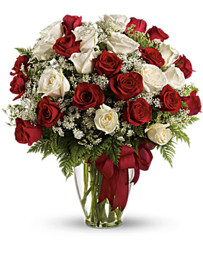 Red and white roses are delivered in a glass vase accented with a red satin ribbon.
Orientation: All-Around