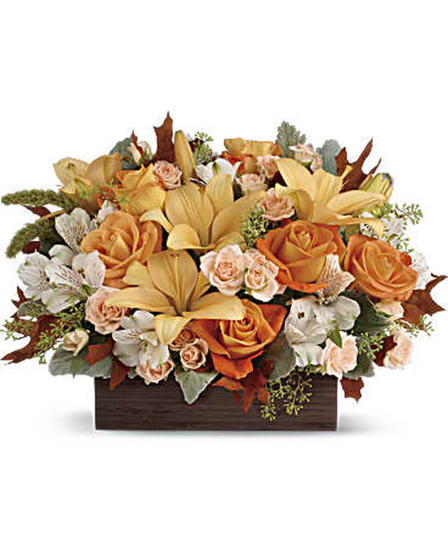 Simply chic and overflowing with fall blooms! This gorgeous arrangement is sure to impress with its glorious shades of autumn - combining orange roses, peach lilies and seasonal brown leaves. Hand-delivered in a dark-toned bamboo rectangle.