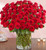 Wow the one you love like never before with 100 stunning long stem red roses! Our spectacular arrangement is artistically designed by our expert floral artisans with an abundant array of dazzling red blooms and lush greenery inside a classic cylinder vase. Standing over 2 feet tall, this luxurious surprise is personally hand-delivered for a grand romantic gesture she’ll remember always.