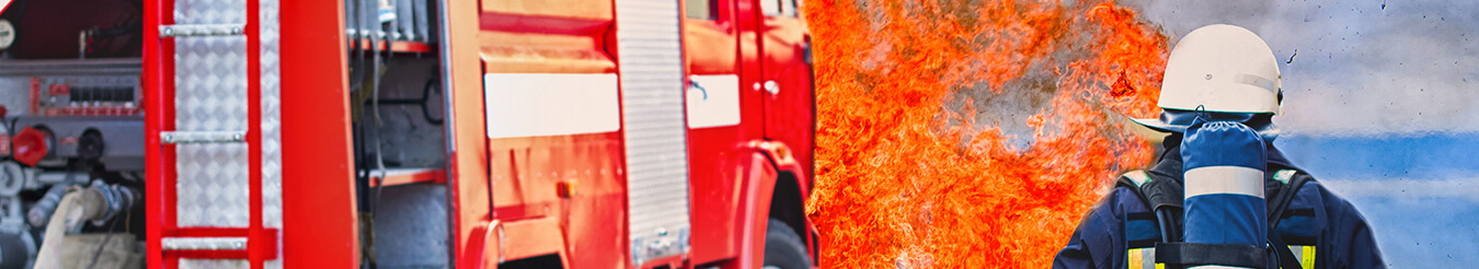 fireman walking towards fire truck and flames