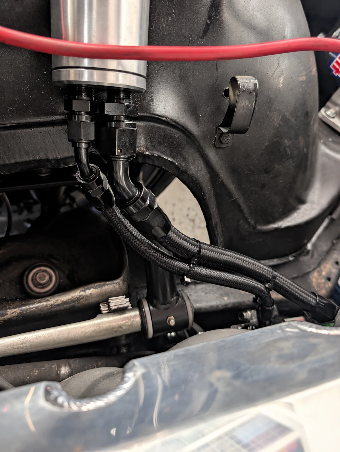 A CVF remote power steering reservoir mounted in an engine bay with AN hoses running down to the pump