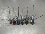 The Sinker Guy Sputnik Sinker, set of fishing sinkers with colored clips and metal wires in various sizes on a textured gray surface.