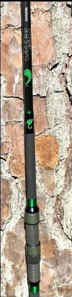 NINJA TACKLE 8'6" Ninja Tackle Dagger, fishing rod with black body, green accents, and ergonomic handle against a textured stone background.