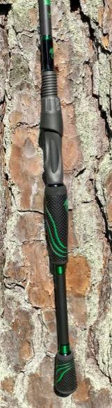 NINJA TACKLE 7' Ninja Tackle Dagger fishing rod, black and green fishing rod with textured handle and green accents, leaning against a tree bark background.