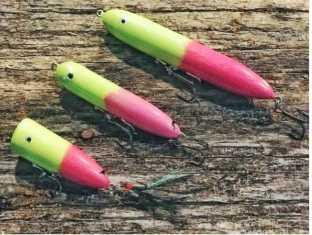 BIRD DOG BAIT Bird Dog Bait Lures Jr. Walker, colorful fishing lures in green and pink colors placed on a wooden surface.