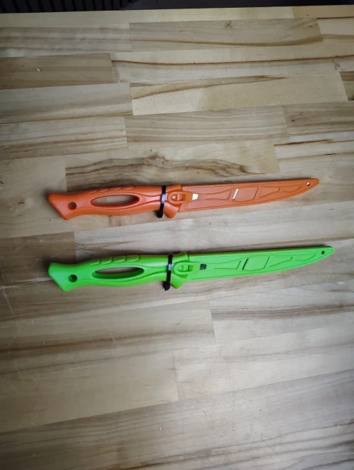TSUNAMI Tsunami 6" Filet Knife, colorful plastic filet knives in orange and green with ergonomic handles on a wooden surface.