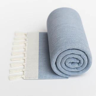 TOADFISH Toadfish Cotton Beach Towel - 6ft, light blue rolled and partially unrolled with fringed edges.