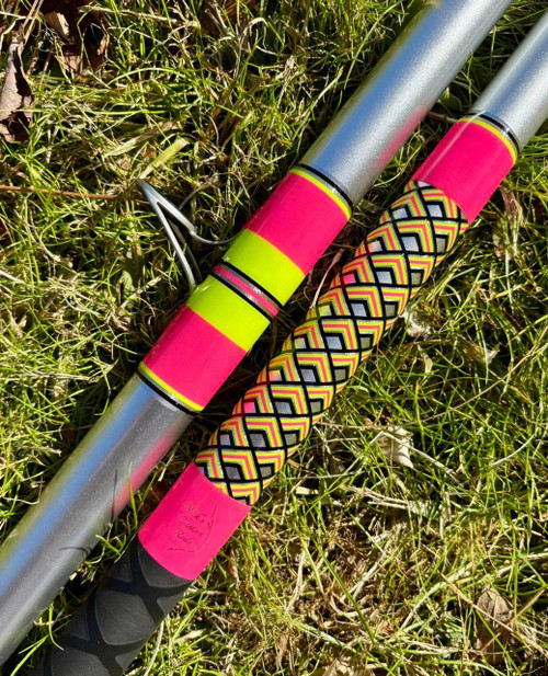 NICK'S CUSTOM RODS 2026 Nick's Custom Rods CTS 1306 Conventional fishing rod, vibrant pink and neon yellow handle with a geometric pattern, lying on green grass.