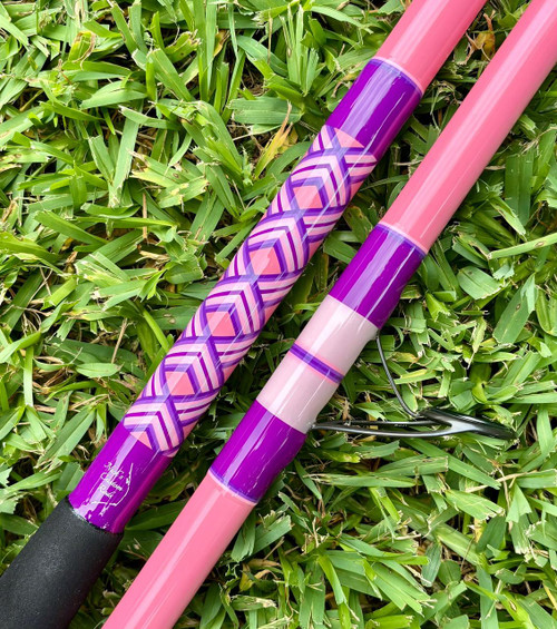 NICK'S CUSTOM RODS 2026 Nick's Custom Rods - CTS 1205 Spinning fishing rod, pink and purple design, lying on green grass.