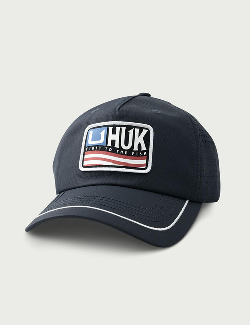 HUK Born Wave Performance Hat, navy blue baseball cap with embroidered patch logo and white piping detail.
