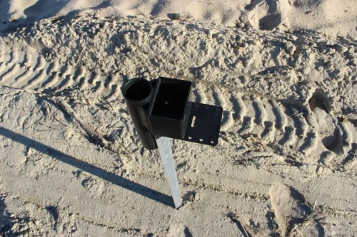 ANGLER'S FISH-N-MATE Angler's Pro Spike, a sturdy black fishing spike mounted on a metal pole in sandy terrain.