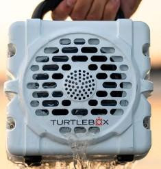 TURTLEBOX Turtlebox Cub, close-up image of the portable rugged Bluetooth speaker with black grille and white casing.