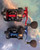 AKIOS Akios F-15 Nitron fishing reels, top view showing red and blue anodized metal spool and handle, with carbon fiber housing and ergonomic rubber grips.