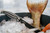 SORD Fishing Products Knives, black fishing knife with a patterned handle resting on ice beside a fish tail