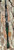 NINJA TACKLE Ninja Tackle 7' Dagger Spinning Rod, fishing rod leaning against a tree trunk with a black handle and green accents.