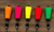FOUR HORSEMEN Four Horsemen Tackle Popper, colorful fishing lure with bright orange, pink, yellow, red, and green bodies on a wooden surface.