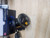 Penn FISHING TACKLE Penn Squall 15 SDCS with Low Profile Knob, fishing reel with compact design and black color, mounted on a wooden surface.