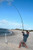 NINJA TACKLE Ninja Tackle 13'3" Dagger Bomber Surf Rod, person casting fishing rod on the beach.