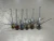 The Sinker Guy Sputnik Sinker, fishing sinkers with colored clips and attached hook wires, arranged in a row on a metallic surface.