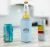 TOADFISH Toadfish Universal Can Koozie, blue insulated can holder with toadfish logo fitting around a soda can and a beer bottle on a kitchen countertop.