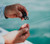 Toadfish Line Nippers, close-up of a person using the line nippers to cut fishing line over water.