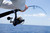 Penn Fishing Tackle Penn Battle IV Spinning Combo, close-up of a person holding a fishing rod with a spinning reel over the ocean, ready for fishing.