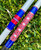 NICK'S CUSTOM RODS 2025 Nick's Custom Rods - CTS 1305, fishing rods with detailed red, blue, and white geometric and striped patterns, lying on green grass.