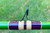 Nick's Custom Rods 2025, close-up of a fishing rod with eyelet and colorful wrapping over a green rod on a grassy background.