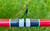 Nick's Custom Rods 2025, close-up of the fishing rod with a black guide and red handle on green grass background.