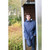 GUY COTTEN Guy Cotten Isoder Jacket - Glentex, a man wearing a waterproof navy blue jacket with a hood, standing outdoors near a wooden shed with autumn foliage in the background.