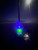 Reel Glo Reel Glo Reel Illuminator, glowing green and blue LED light on a fishing rod in dark nighttime setting