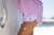 HUK Pursuit Printed Volley Short, close-up of pink and white tie-dye shorts worn by a person on a boat.