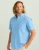 HUK Kona Solid SS, a man wearing a light blue short-sleeve button-up shirt with a pocket on the left chest.