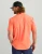 HUK Kona Solid SS, a men's coral short-sleeve button-up shirt worn by a male model with a black and gray trucker cap.